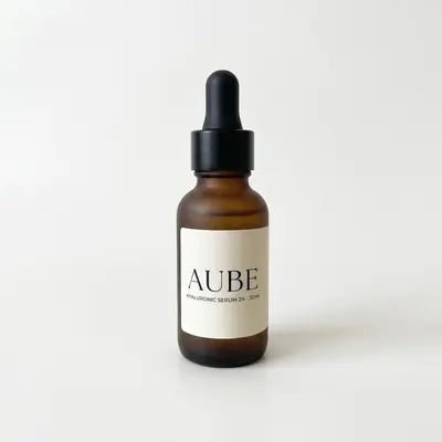 Packshot généré par Scale for You : le sérum AUBE en flacon compte-gouttes ambré sur fond studio blanc